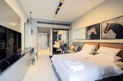 a bedroom with a large bed and a living room at Studio - MAG 318 in Dubai