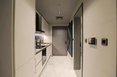 a kitchen with white walls and white floors and a hallway at Studio - MAG 318 in Dubai