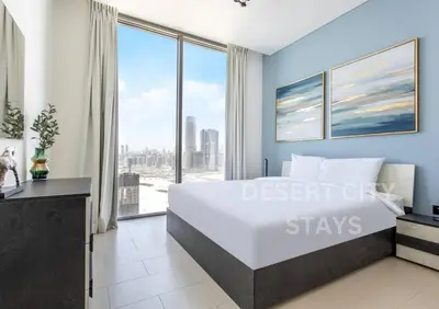 a bedroom with a large bed and a large window at 2 Bed in Sobha Creek Vista Reserve with Burj Khalifa views hosted by Desert City Stays in Dubai