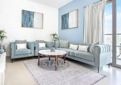 a living room with a couch and a table at 2 Bed in Sobha Creek Vista Reserve with Burj Khalifa views hosted by Desert City Stays in Dubai