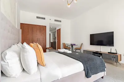 a bedroom with a large bed and a flat screen tv at Silkhaus spacious studio in Boulevard Central with gym & pool in Dubai