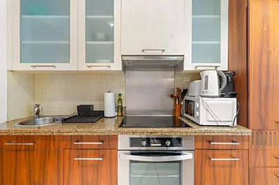 a kitchen with a sink and a stove top oven at Silkhaus spacious studio in Boulevard Central with gym & pool in Dubai