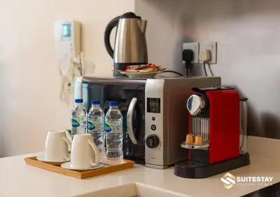 a kitchen counter with a microwave and bottles of water at Deluxe - Address Dubai Mall - The Residence in Dubai