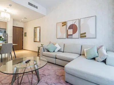a living room with a couch and a glass table at Stylish 1BR in Park Heights 2 - Dubai Hills in Dubai