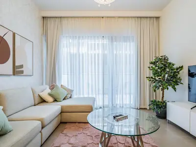 a living room with a couch and a glass table at Stylish 1BR in Park Heights 2 - Dubai Hills in Dubai