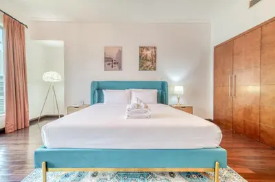 a bedroom with a large bed with a blue headboard at South Ridge 2, Downtown Dubai - Mint Stay in Dubai