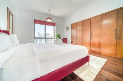 a bedroom with a large white bed with wooden cabinets at South Ridge 2, Downtown Dubai - Mint Stay in Dubai