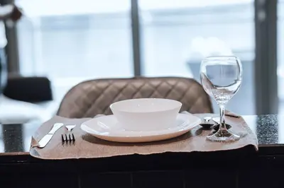 a table with a plate and a glass of wine at Panoramic Luxe 1BR with Breathtaking Views at Dubai Marina Near JBR - Silverene Towers in Dubai