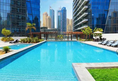a large swimming pool with a city skyline in the background at Panoramic Luxe 1BR with Breathtaking Views at Dubai Marina Near JBR - Silverene Towers in Dubai
