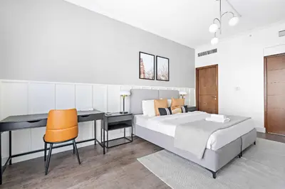 a bedroom with a bed and a desk and a desk at Silkhaus high floor 1BDR in Southridge in Dubai