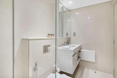 a white bathroom with a sink and a shower at Silkhaus elegant 1BDR in Downtown premium tower in Dubai