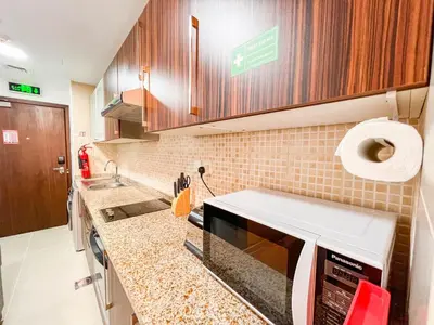 a kitchen with a sink and a counter top at Cosmos Living Luxurious Studio Near Metro in Dubai