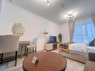 a bedroom with a bed and a desk and a table at Cosmos Living Luxurious Studio Near Metro in Dubai