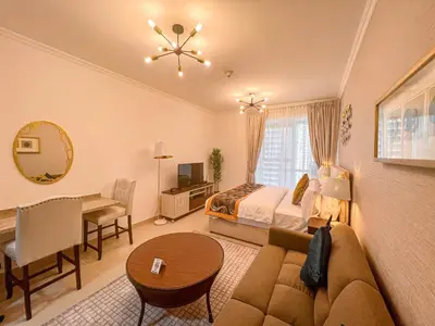 a bedroom with a bed and a couch and a table at Cosmos Living Luxurious Studio Near Metro in Dubai