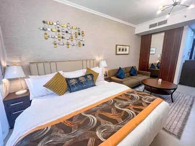a bedroom with a large bed and a living room at Cosmos Living Luxurious Studio Near Metro in Dubai