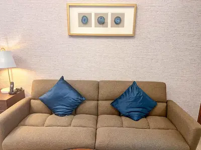 two blue pillows sitting on a couch in a room at Cosmos Living Luxurious Studio Near Metro in Dubai