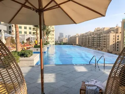 a large swimming pool with an umbrella on a building at GuestReady - Bejeweled Studio at The Palm Tower in Dubai