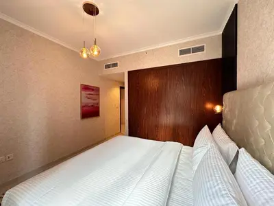a bedroom with a bed with a wooden head board at Durrani Homes - Supreme 5BR besides Dubai Mall With Burj Khalifa and Fountain view in Dubai