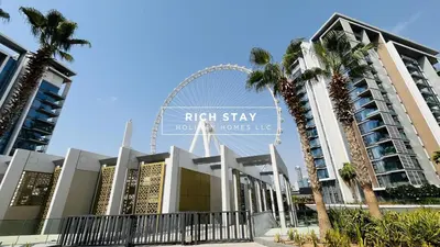 a large building with a ferris wheel in the background at Crystal Clear 1BR in Blue Waters with Ain View in Dubai