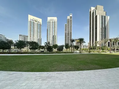a park in a city with tall buildings at Trophy Lux 2BR Creek Harbour Suites with Iconic Burj Khalifa Views in Dubai