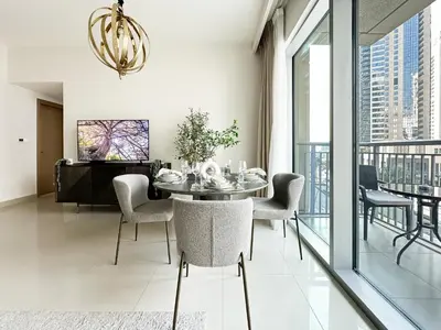 a dining room with a table and chairs at Trophy Lux 2BR Creek Harbour Suites with Iconic Burj Khalifa Views in Dubai