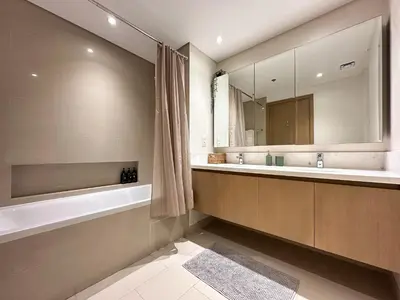 a bathroom with a tub and a sink and a mirror at Trophy Lux 2BR Creek Harbour Suites with Iconic Burj Khalifa Views in Dubai