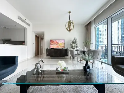 a living room with a table and a dining room at Trophy Lux 2BR Creek Harbour Suites with Iconic Burj Khalifa Views in Dubai