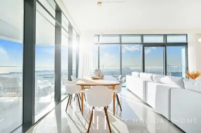 a room with white chairs and a table and windows at LUX The ULTRA Luxury Palm Dubai Eye View Suite in Dubai