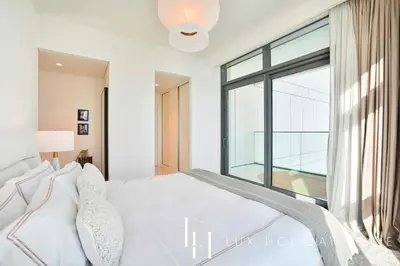 a bedroom with a white bed and a large window at LUX The ULTRA Luxury Palm Dubai Eye View Suite in Dubai