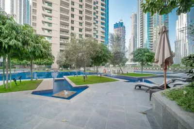 a park with benches and an umbrella in a city at Bellavista - Splendid - 2BR plus Maid - 29 Boulevard - Burj Khalifa & Fountain in Dubai