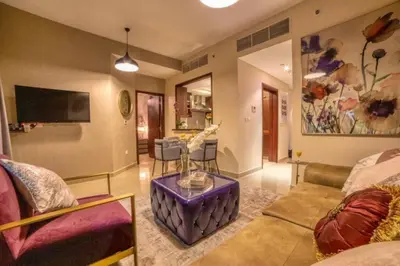 a living room with a couch and a tv at Bellavista - High Floor - 1BR - 29 Boulevard - Burj Khalifa & Fountain View in Dubai