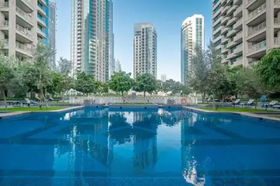 a large swimming pool in a city with tall buildings at Bellavista - High Floor - 1BR - 29 Boulevard - Burj Khalifa & Fountain View in Dubai