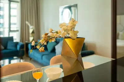 a vase with flowers on a table in a living room at Bellavista - Graceful - 2 BR - 29 Boulevard - Fountain Views in Dubai