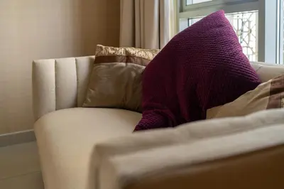 a purple pillow sitting on a couch next to a window at Bellavista - Graceful - 2 BR - 29 Boulevard - Fountain Views in Dubai