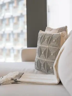 a pillow sitting on a bed next to a window at Lavishly Elegant 2BR with Breathtaking Full Burj Khalifa View in Dubai