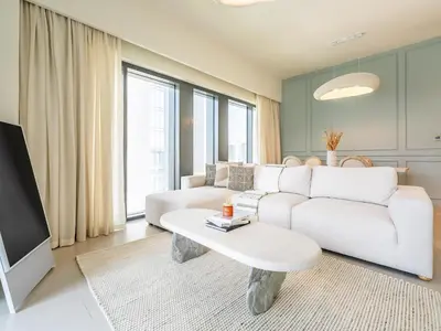 a living room with a white couch and a table at Lavishly Elegant 2BR with Breathtaking Full Burj Khalifa View in Dubai