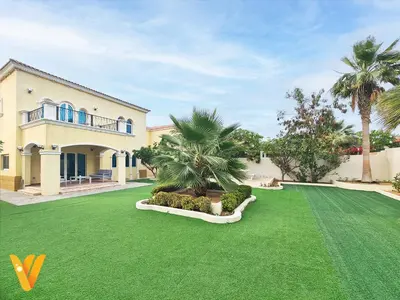 a house with a yard with green grass and palm trees at Luxury 3BR Private Pool Villa and Elaborate Gardens in Dubai