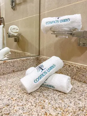 a bathroom with towels on a counter in front of a mirror at Cosmos Living Stylish Studio Near Marina in Dubai