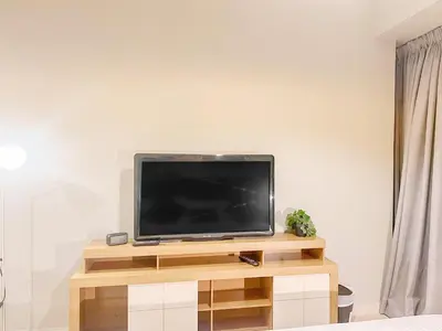 a flat screen tv sitting on top of a wooden entertainment center at Cosmos Living Stylish Studio Near Marina in Dubai