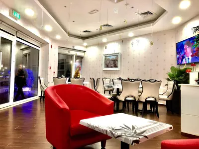 a restaurant with a red chair and a tables and chairs at Cosmos Living Stylish Studio Near Marina in Dubai