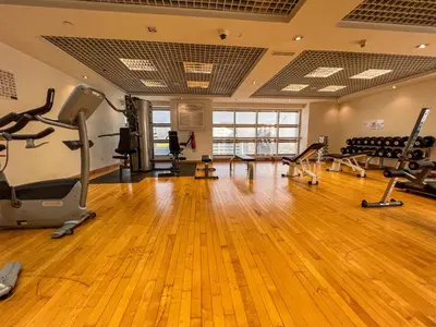 a gym with treadmills and exercise equipment in a room at Cosmos Living Stylish Studio Near Marina in Dubai
