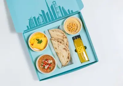 a bento box with a lunch of bread and food at Cosmos Living Stylish Studio Near Marina in Dubai