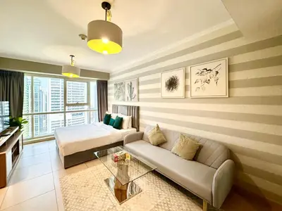 a living room with a bed and a couch at Cosmos Living Stylish Studio Near Marina in Dubai