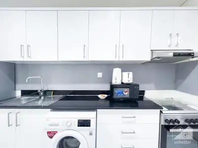 a kitchen with a sink and a washing machine at NEW! Amazing Studio in Al Majan in Dubai