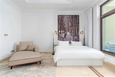 a bedroom with two beds and a chair and a window at NEW! Exclusive Fairmont Penthouse private Pool-Gym in Dubai