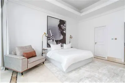 a white bedroom with a bed and a chair at NEW! Exclusive Fairmont Penthouse private Pool-Gym in Dubai