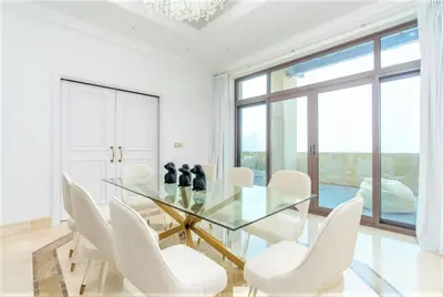 a dining room with a glass table and white chairs at NEW! Exclusive Fairmont Penthouse private Pool-Gym in Dubai