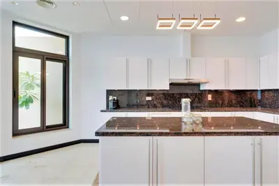 a kitchen with white cabinets and a large island at NEW! Exclusive Fairmont Penthouse private Pool-Gym in Dubai
