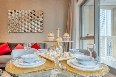 a dining room table with glasses and plates and cupcakes at Bellavista - Magnificent - 3BR - 29 Boulevard - Partial Burj Khalifa & Fountain Views in Dubai