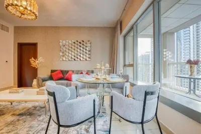 a living room with a table and chairs and a couch at Bellavista - Magnificent - 3BR - 29 Boulevard - Partial Burj Khalifa & Fountain Views in Dubai